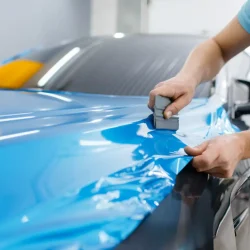 car-wrapping-mechanic-with-squeegee-installs-film